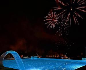 a swimming pool with fireworks exploding in the sky at GrandPalazzo Apartments in Vir