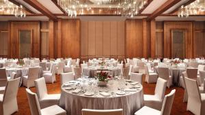 a conference room with tables and chairs and chandeliers at InterContinental One Thousand Island Lake Resort, an IHG Hotel in Chun'an