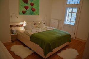Schlafzimmer mit einem Bett mit grüner Bettwäsche und einem Fenster in der Unterkunft Landgasthof Alter Bahnhof in Heyerode