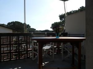 y balcón con mesa y sillas de madera. en Il Cinqualino locazione turistica, en Cinquale