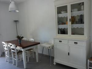 un comedor con un armario blanco y una mesa en Il Cinqualino locazione turistica, en Cinquale