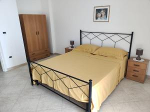 ein Schlafzimmer mit einem großen Bett und einem Holzschrank in der Unterkunft Casa Vacanze Riccio di Mare in Santa Maria di Leuca