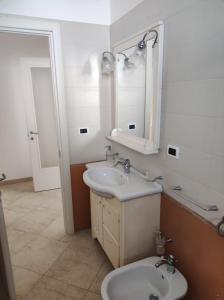 ein Badezimmer mit einem Waschbecken, einem Spiegel und einem WC in der Unterkunft Casa Vacanze Riccio di Mare in Santa Maria di Leuca