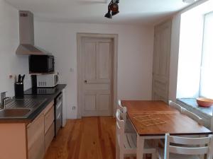 a kitchen with a wooden table and a counter top at Gîte Les Mésanges in Puygros
