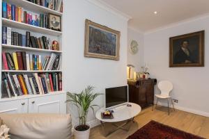 a living room with a couch and a table and books at 2 bed room flat near Westfield, West London in London