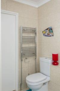 a bathroom with a white toilet and a red candle at 2 bed room flat near Westfield, West London in London