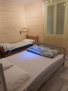 Dos camas individuales en una habitación con ventana. en La Bourboule, en La Bourboule