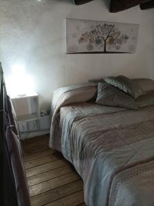 a bedroom with a bed and a tree picture on the wall at LA CASETTA DI MARTA ai Quattro Canti di Giusi in Palermo