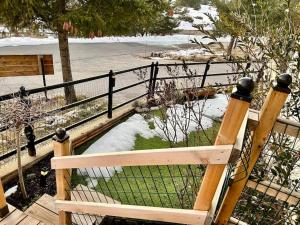 a wooden bench with snow on it next to a fence at Location studio jardin/terrasse in Gréolières