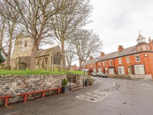 a large red brick building with a stone wall at Coastguard Cottages in Hull