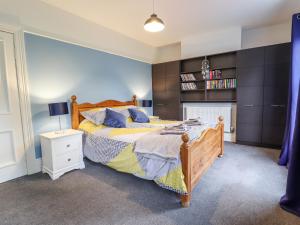 a bedroom with a bed and a book shelf at Coastguard Cottages in Hull