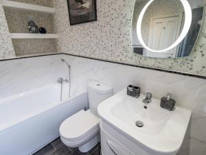 a bathroom with a toilet and a sink and a mirror at Coastguard Cottages in Hull +23 photos