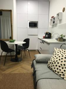 a living room with a table and a kitchen at Greatforest Rosehill 2 Apartman in Debrecen