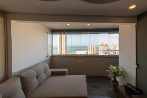 sala de estar con sofá y ventana grande en Modern apartment with Ocean View - 500m from Beach, en Fortaleza