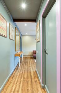 a hallway with blue walls and a wooden floor at Self check in Miera Art Apartment in Rīga