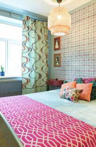 een slaapkamer met een groot bed en een roze deken bij Self check in Miera Art Apartment in Rīga