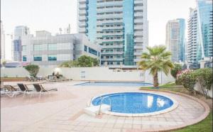 une piscine au milieu d'une ville avec de grands bâtiments dans l'établissement Royal Marina Inn, à Dubaï