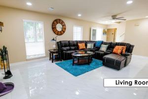sala de estar con sofá de cuero negro en Stunning Family Home in North Houston!!! - Briar Creek, en Spring