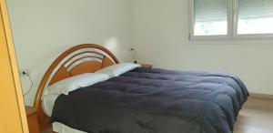 1 dormitorio con 1 cama con edredón azul en modern appartament en Porlezza