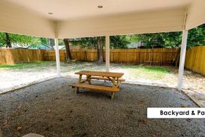 un banco de madera sentado bajo una sombrilla en un patio en Stunning Family Home in North Houston!!! - Briar Creek, en Spring