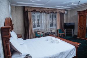 a hotel room with a bed and a television at SELFIE + in Semey