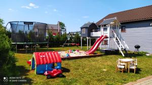 un patio con parque infantil con tobogán y juego en Perła Bałtyku en Jezierzany