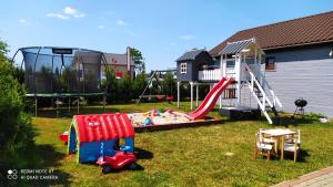 a yard with a playground with a slide and a play set at Perła Bałtyku Jarosławiec in Jezierzany