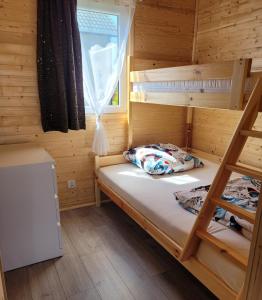 a room with two bunk beds and a window at Perła Bałtyku Jarosławiec in Jezierzany