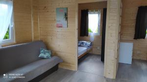 a small room with a couch and a window at Perła Bałtyku Jarosławiec in Jezierzany