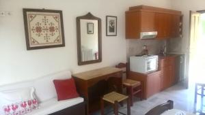 a living room with a microwave and a kitchen at ΚΤΗΜΑ ΦΤΟΥΛΗΣ in Skiros