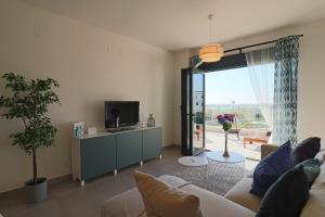 salon z kanapą i telewizorem w obiekcie Enjoy La Reserva El Rompido w mieście El Rompido