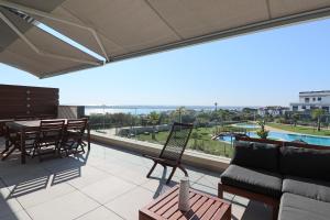 balkon z kanapą, stołem i krzesłami w obiekcie Enjoy La Reserva El Rompido w mieście El Rompido