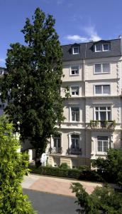 un grande edificio bianco con un albero di fronte di Hotel Beethoven a Francoforte sul Meno