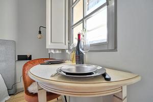 a table with a wine glass and a bottle on it at Au cœur des Papes, dans bâtisse de charme studios & appartements en cœur de ville in Avignon