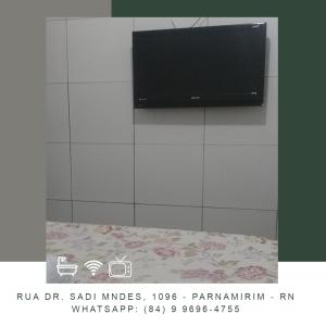 a flat screen tv hanging on a wall at Pousada Jardim do Éden in Parnamirim