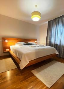 a bedroom with a large bed with a wooden headboard at Csillag Panzio in Lunca de Jos +58 photos