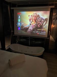 a flat screen tv with a movie projected on it at L'Escale Royale L'Isle Adam à 20 minutes de Paris CDG in LʼIsle-Adam