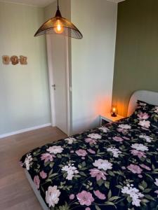 een slaapkamer met een bed met een bloemdekbed bij "VH apartment" - center of Antwerp - free parking in Antwerpen