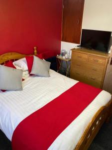 1 dormitorio con 1 cama grande y pared roja en Southway Double Room near Derriford, en Plymouth