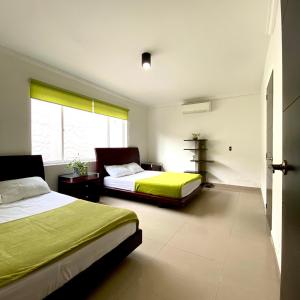 een slaapkamer met 2 bedden en een raam bij CASA PALMA CARTAGENA in Cartagena