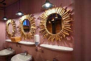 a bathroom with three mirrors on the wall with sinks at Sleep Space 24 - Green Tiny Village Harz in Osterode +39 photos