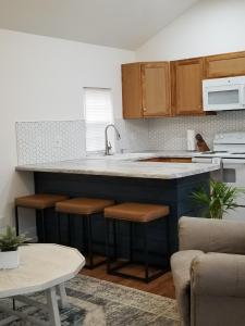 Tiny home rentals near Ft Moore في فينيكس سيتي: مطبخ مع حوض ومكتب مع الكراسي