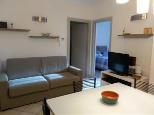 a living room with a couch and a television at Raki Apartment in Fano