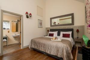 een slaapkamer met een bed, een wastafel en een spiegel bij Irishman's Cottage in York