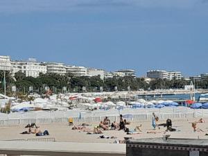 a group of people laying on a beach with umbrellas at Stella Apartment - Cannes in Cannes
