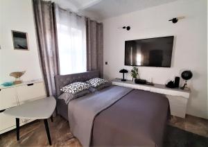 a bedroom with a bed and a tv on the wall at Studio Four - prywatne wejście i taras w Centrum Sopotu in Sopot