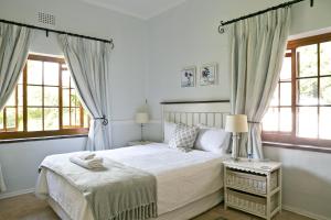 una camera da letto con un letto e due finestre di Grace Guest House a Johannesburg