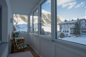 a room with a window with a view of a snowy mountain at Apart Bergli in Galtür