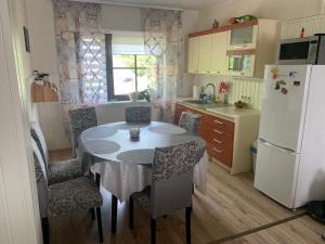 a kitchen with a table and chairs and a refrigerator at Keldrimäe külalistemaja in Hiiumaa