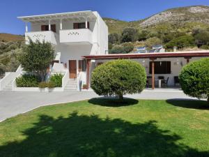 a large white house with trees in the yard at ΚΤΗΜΑ ΦΤΟΥΛΗΣ in Skiros